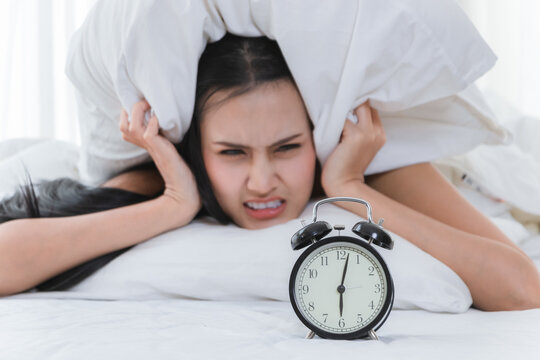 Beautiful Woman Using A Pillow Close The Ear For Can't Hear The Alarm Clock In The Morning