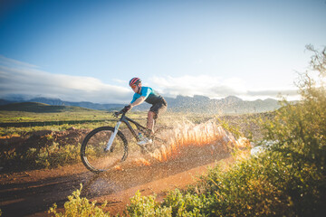 Naklejka premium Wide angle view of a mountain biker speeding downhill on a mountain bike track.