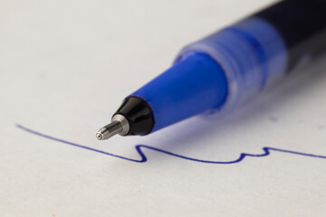 Fototapeta premium macro photo of the blue ballpoint pen on the white page paper