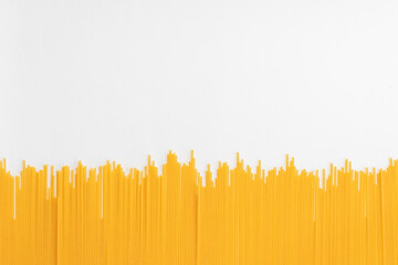 Raw dry spaghetti italian pasta yellow long line on white background with copy space. Concept...