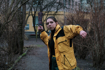 Bad girl bully in yellow coat in the backyard. Outdoor lifestyle portrait