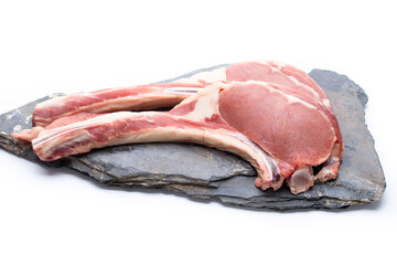 Fresh raw beef two tomahawk steak on black stone slate isolated on white background.