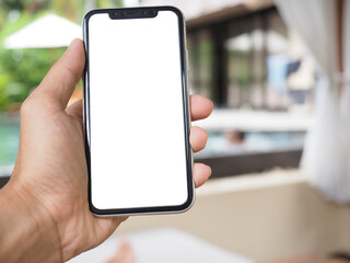 Holding Mobile Smart Phone In Hand at swimming pool. Phone screen in white color for die cut.