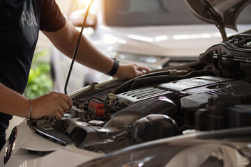 Technician working on checking and service car in auto service. Technician repair and maintenance engine holding wrench in hand.