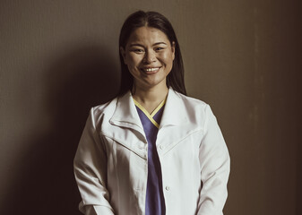 Happy doctor or nurse broadly smiles looking at camera isolated on gray background. Hope concept. Tinted image.