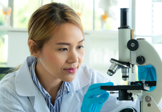 Young scientist looking through a microscope in a laboratory. Health care researchers working in life science laboratory