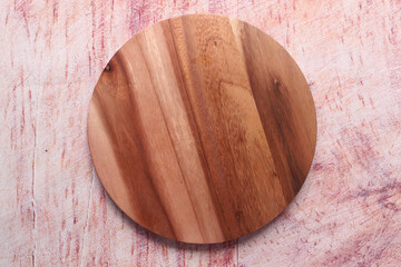 Top view of wooden chopping board on wooden background .