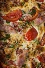 pizza with salami and olives. ham, tomato and cheese omelette in a baking dish