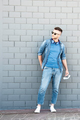 Obraz premium Young man with headphones around his neck and surgical protective mask in his hand posing after coronavirus outbreak - Outfit, technology and lifestyle after covid-19 lockdown - New normal concept