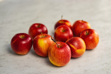 Red apples lie on a light table. Close up