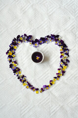 Heart shaped pansies around a mug