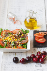 salad with lamb's lettuce and chia, on a rustic white table with oil,  and cut tomato