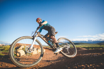 Fototapeta na wymiar Wide angle view of a mountain biker speeding downhill on a mountain bike track.