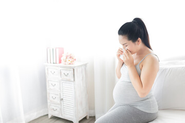 pregnant asian female use tissue paper close her mouth and nose, she cough and feeling fever, pregnancy promotion healthcare, influenza immunization, coronavirus disease
