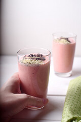 Female hand holding the glass of raspberry smoothie