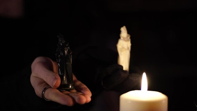 black and white figurines next to the candle flame