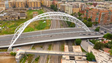 Fototapeta premium Aerial view of the Settimia Spizzichino bridge known as Ostiense overpass. This iron arch bridge is located in the Garbatella district in Rome, Italy