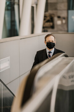 Europe, Germany, Hamburg, Hafencity, Businessman wearing a respirator face mask in public on a staircase