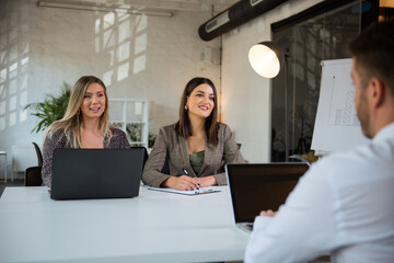 Two very beautiful business woman talking to a client