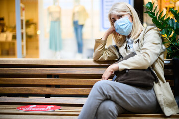 Portrait of a sad thinking woman wearing a mask to protect from covid 19 pandemic virus