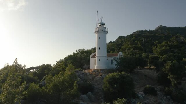 Gelidonya lighthouse on a background of mountains. Beautiful ladscape with green trees. Drone video footage 4K