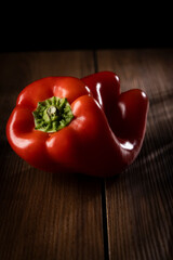 Red  bell peppers, lit on a wooden table.