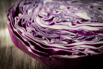 Fototapeta premium Purple cabbage lit on a wooden talbe.