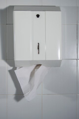 white paper towel dispenser in public toilet