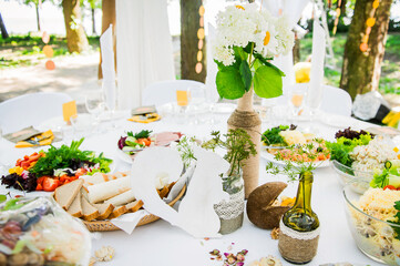 Decoration of the festive table with flowers, greenery and wooden figures. Accessories made of natural materials for restaurant service