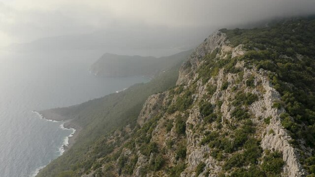 Flying through the clouds above mountain tops. Mediterranian sea. Natural landscape 