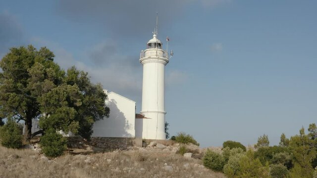Gelidonya lighthouse on a background of mountains. Beautiful ladscape with green trees. Drone footage 4K