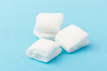 White gauze pads on  blue background. Materials for dental surgery. Close up