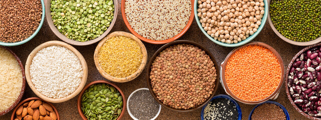 Collection of a various of legumes, beans, grains and seeds in bowls, banner. Top view, flat lay, space for your text, border.