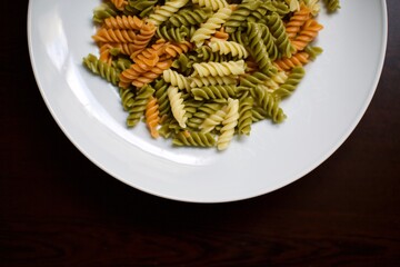 Vegetables pasta. Yellow, green and orange colors with white porcelain plate. Close up view.