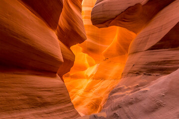 Sunlight shining on the wall of the slot canyon causes the wall to glow brightly in lower Antelope Canyon, Page, Arizona