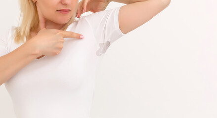 woman shows a spot on her white t-shirt