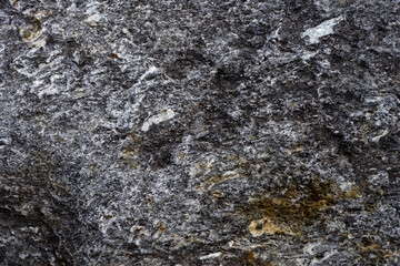 Natural stone grey granite background. Bright hard grey granite rock texture. Grey granite stone background. Grey granite untreated surface. Facing material full frame horizontal texture. Granite
