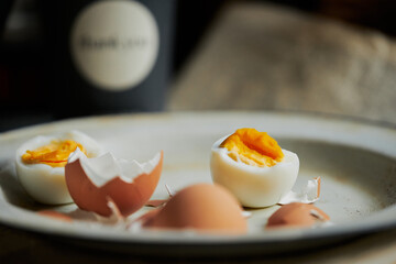 Defocused background with ready to eat eggs in vintage enamel plate. Behind blurred bacground
