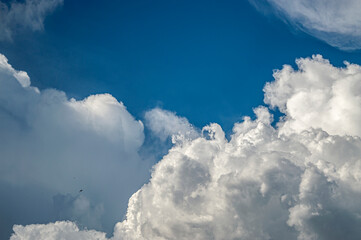 Naklejka na ściany i meble white fluffy clouds on a blue sky on a summer day background