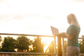 Portrait of busy sales woman sitting at business park and using her laptop. Businesswoman working...
