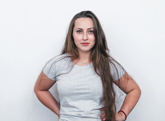 Portrait of a girl with long dark hair on a white background looking at the camera.