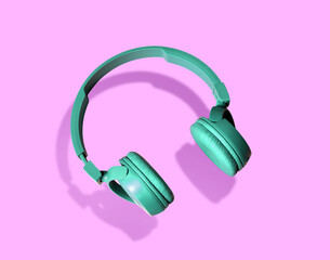 Headphones. Green headphones on pink background. Headphones on pink background. Sounds. Music concept. Smart. Наушники. 