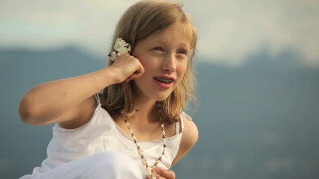 Young girl playing phone with a shell
