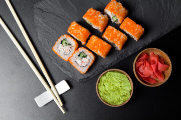 Sushi CALIFORNIA rolls with wasabi and ginger on a Board made of stone. Sushi food photo for menu.The view from the top