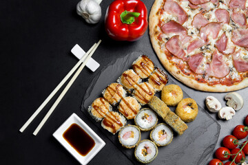 Pizza and sushi rolls tempura and bake rolls on the background of ingredients .Pizza, sushi food photo for menu. Combo set of rolls and pizza.