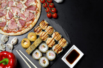 Pizza and sushi rolls tempura and bake rolls on the background of ingredients .Pizza, sushi food photo for menu. Combo set of rolls and pizza.