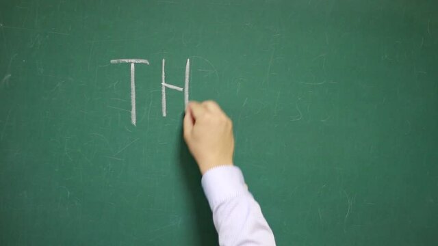 Hand writes THE END on a blackboard