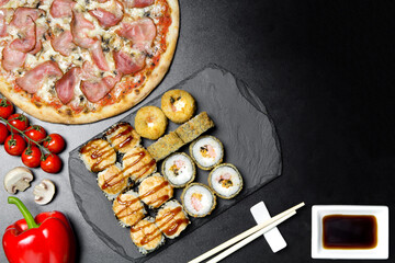 Pizza and sushi rolls tempura and bake rolls on the background of ingredients .Pizza, sushi food photo for menu. Combo set of rolls and pizza.