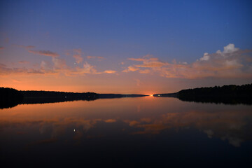 landscape with bright clouds and with reflections in the river before dawn