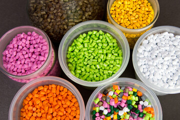 Plastic granules in a measuring container and test tubes in the laboratory. Plastic pellets. Dyes for plastic, polypropylene, polyethylene